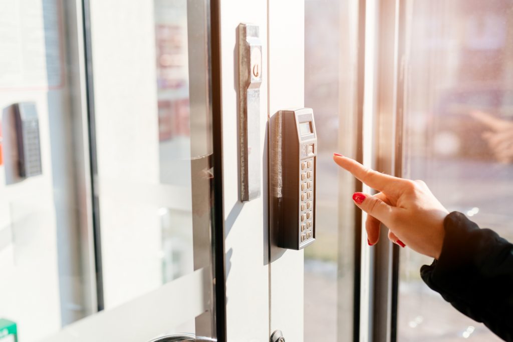 A woman entering a pin code to the security alarm system in an office