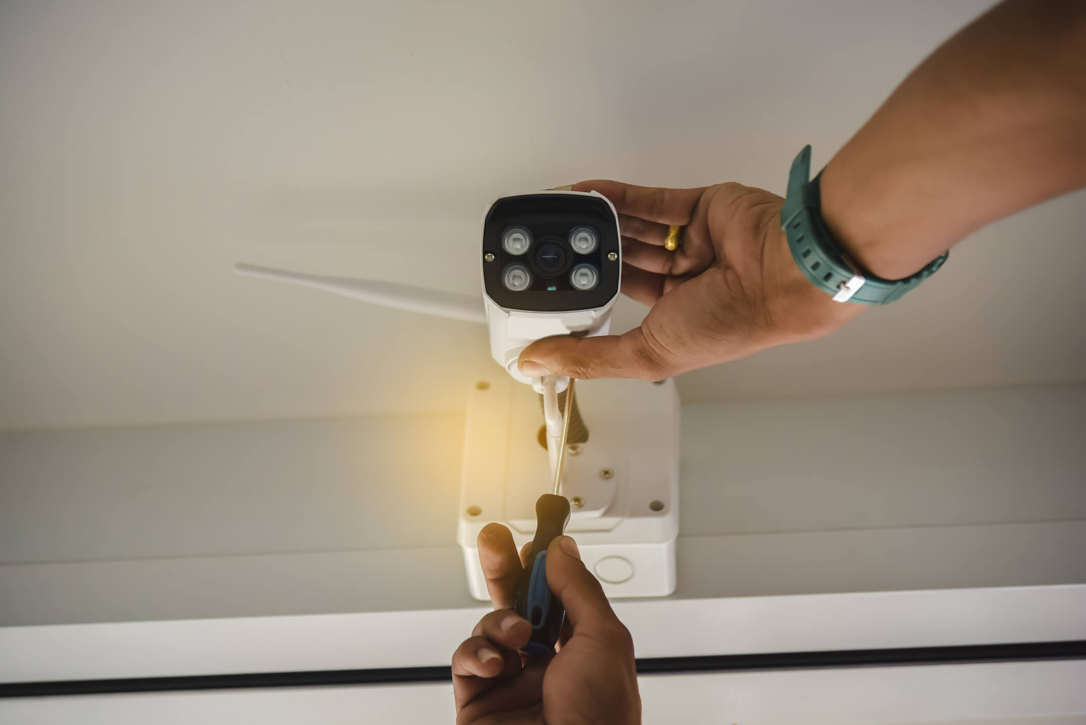 Technician installing wireless CCTV camera by screwed for home security system and installed